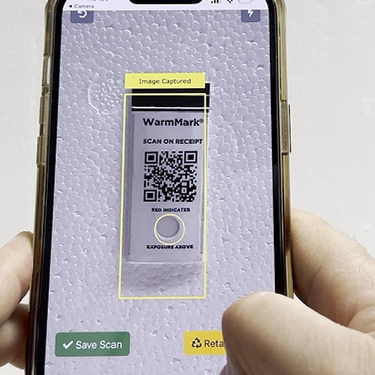 A phone camera scanning a WarmMark QR indicator on receipt: the card, marked Scan on receipt, Red indicates and Exposure above, framed on screen with Image captured and a Save scan button